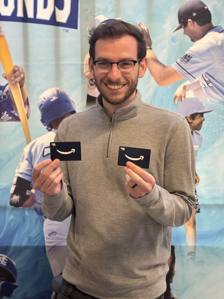 A DockHounds winner holding two gift cards