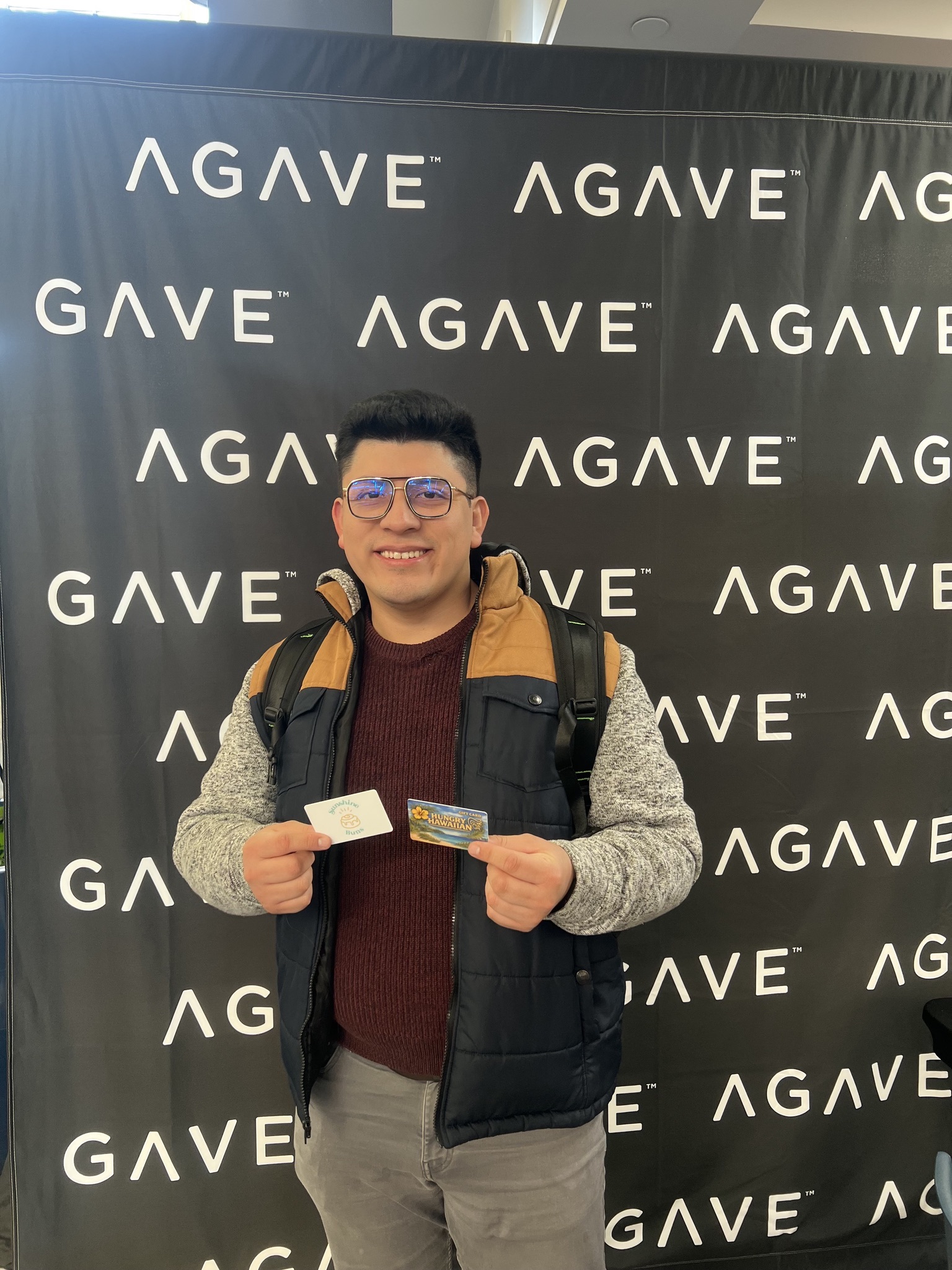 A giveaway winner holding his gift cards at an Agave event