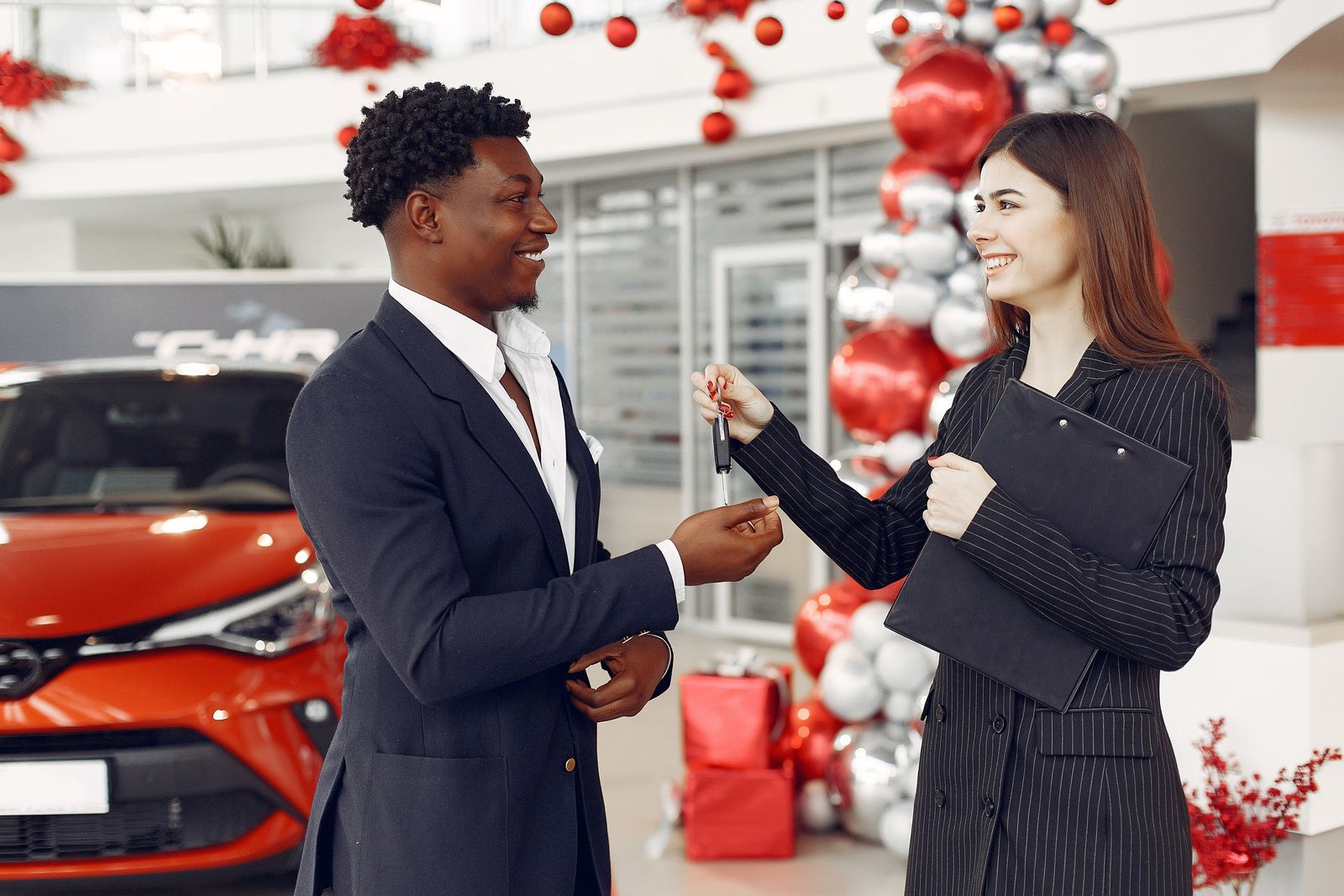 Illustrative showroom photograph of a customer receiving the keys to a new vehicle